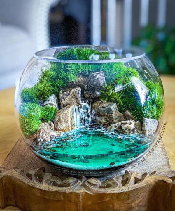 First attempt at a Faux Waterfall Terrarium. Water is glow in the dark!  Products used: Fishbowl, polymer clay, uv resin, epoxy resin, sand, fake  moss, Perfect Cast plaster, tan paint, hot glue. 