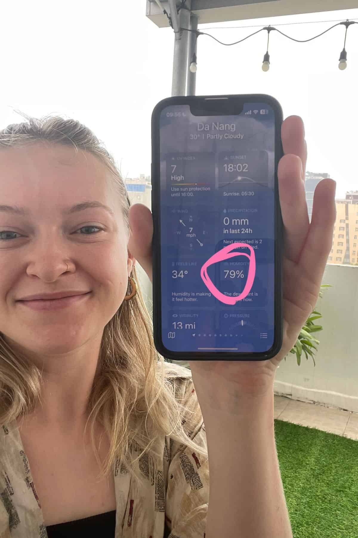 Person holding phone showing 79% humidity real time humidity in Vietnam