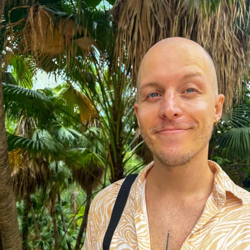 headshot of man against backdrop of trees